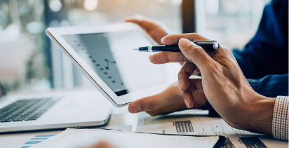 focus on the hands of a person using a laptop to input their credit card number while holding up the card